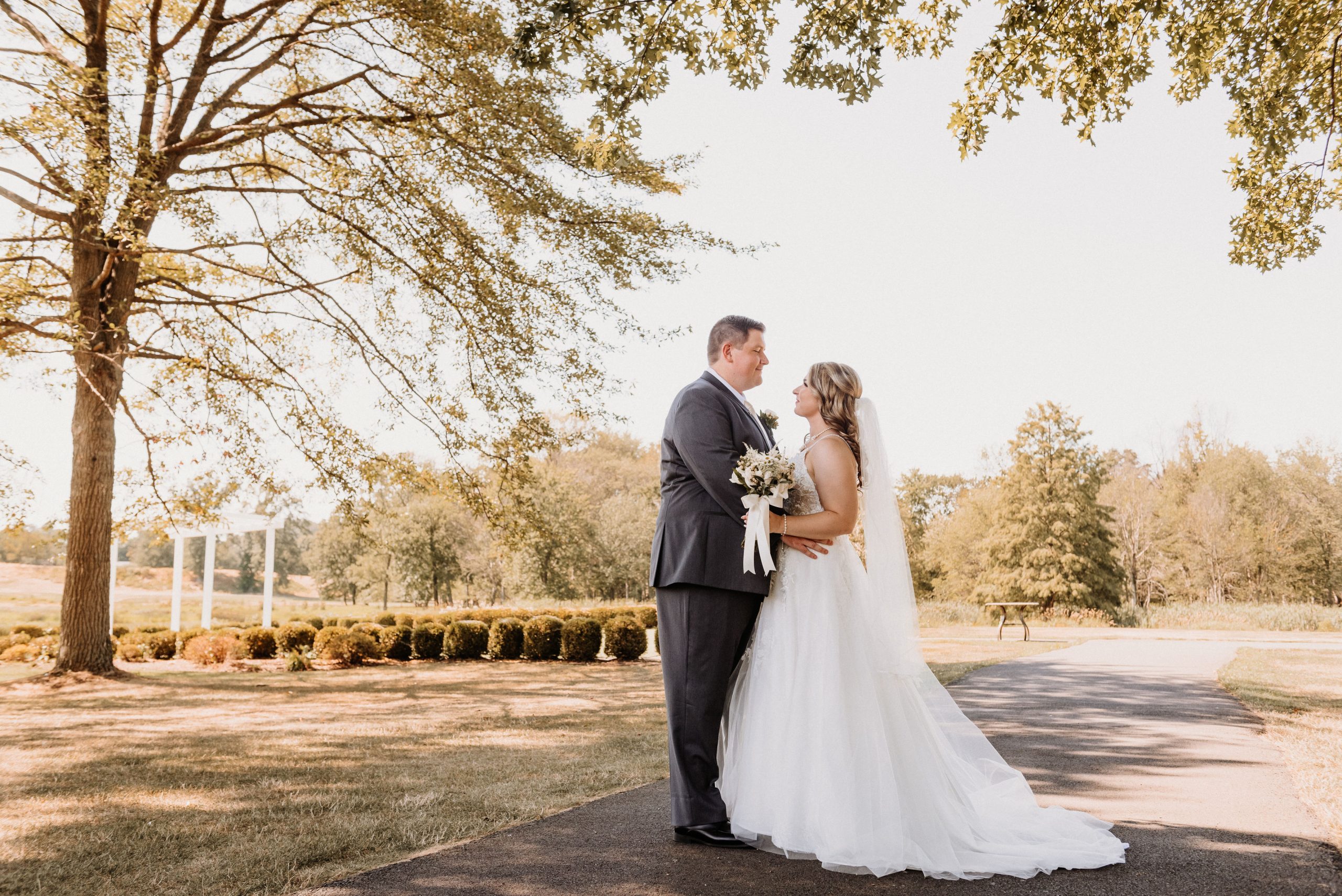 A bride and groom on the golf course at The Clubhouse at Galloping Hill in Kenilworth, New Jersey with the outdoor ceremony site behind them