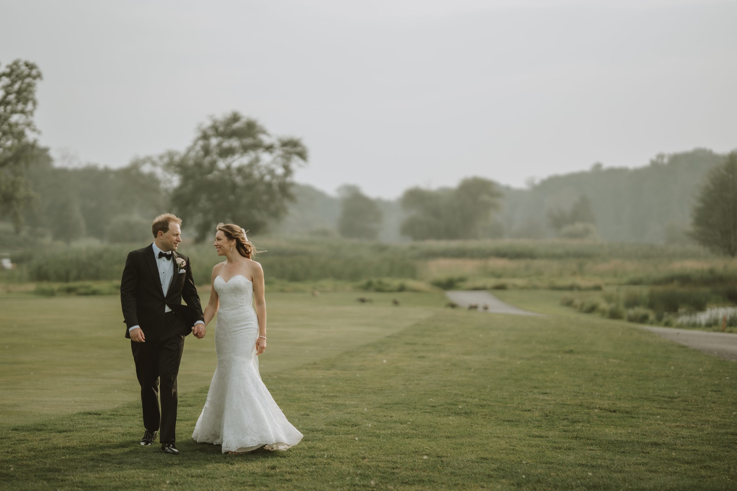 A bride and groom walking on the golf course at The Clubhouse at Galloping Hill in Kenilworth, New Jersey